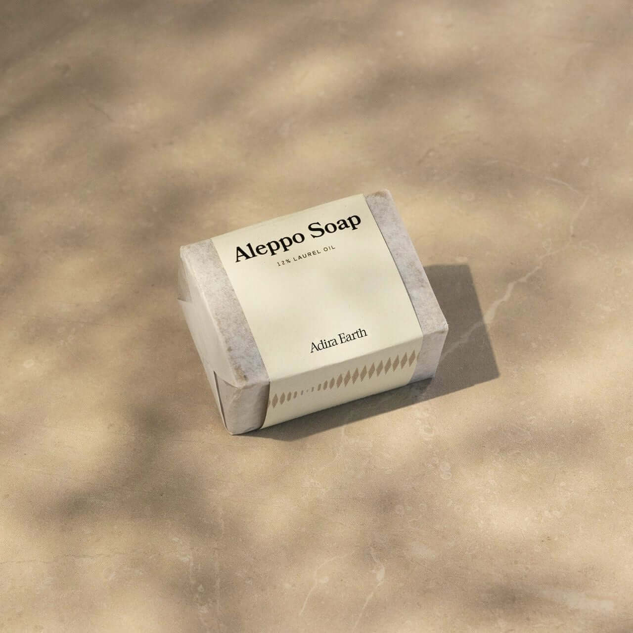 Aleppo soap bar with olive and laurel oils on a neutral background, showcasing natural skincare product.