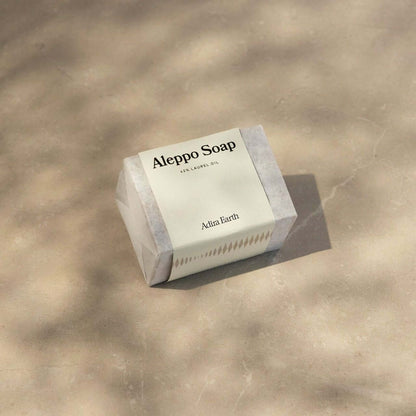 Natural Aleppo Soap Bar on a stone surface, featuring olive and laurel oils for gentle cleansing and revitalizing skincare.