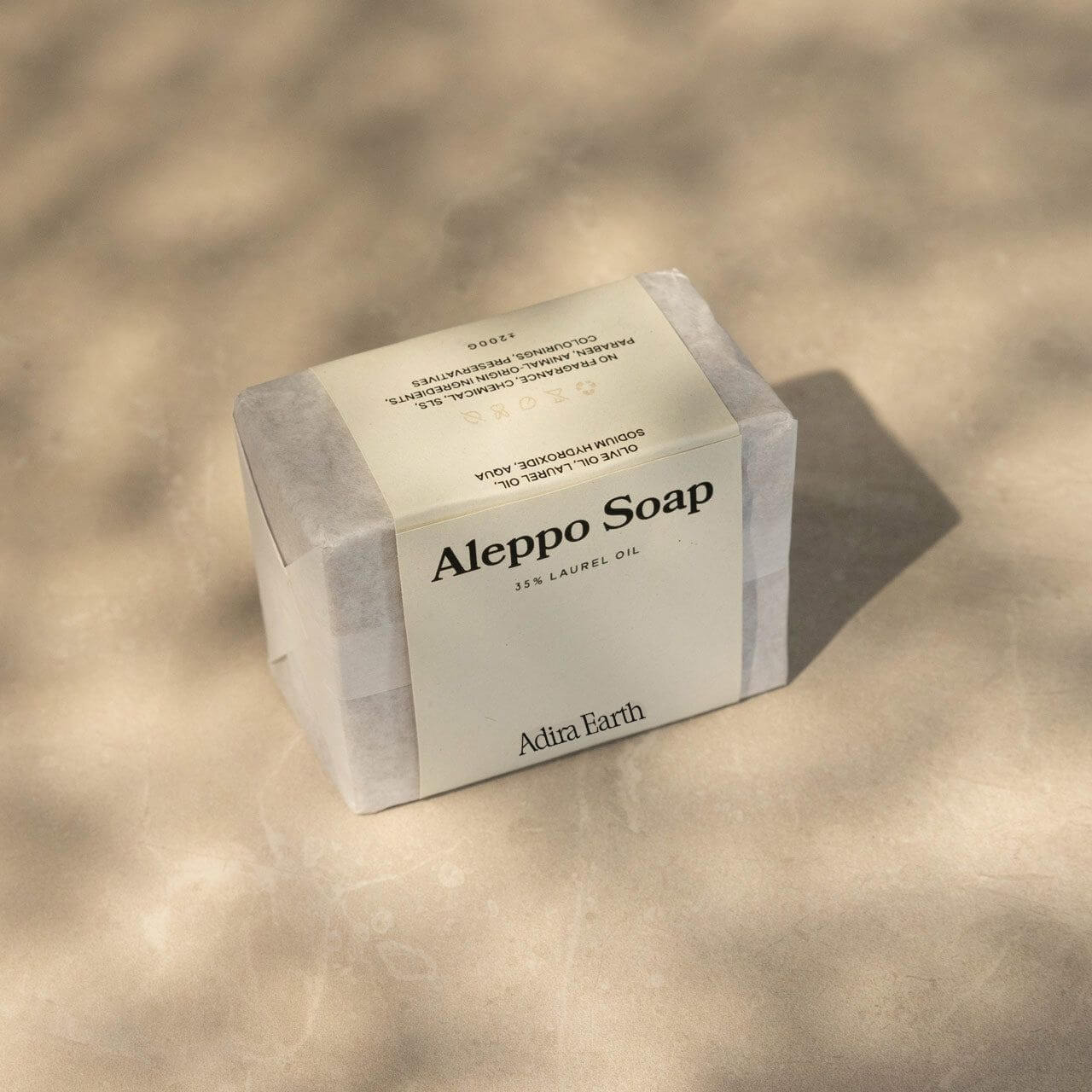 Aleppo soap bar with packaging, featuring natural laurel oil and olive oil ingredients, highlighting eco-friendly skincare from Adira Earth.