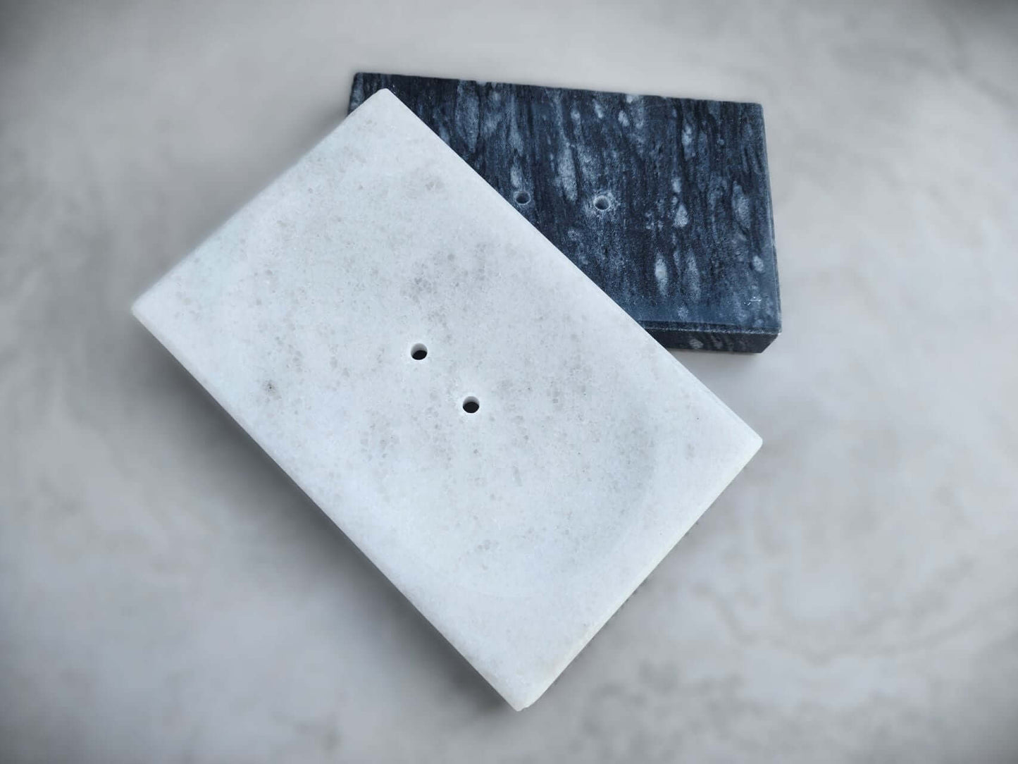 Elegant marble soap dishes in white and dark stone, perfect for adding sophistication to bathroom decor.