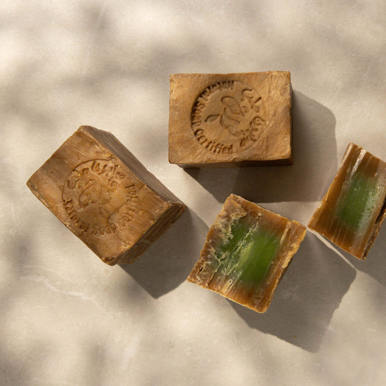 Aleppo soap bars with natural olive and laurel oils on a marble surface.